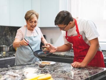 Persona mayor cocinando con su nieto