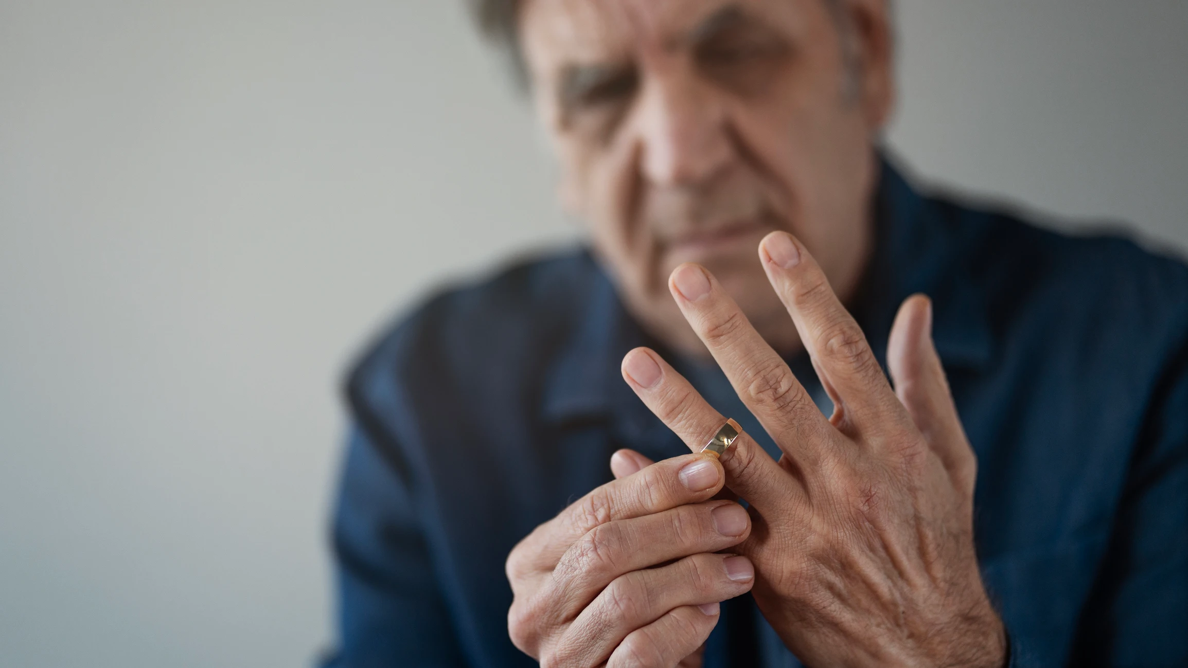 Divorcio: hombre mayor quitándose el anillo de casado Divorcio: hombre mayor quitándose el anillo de casado