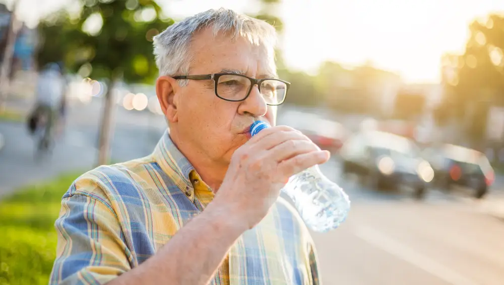 Persona mayor bebiendo una botella de agua