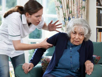 Una cuidadora agarra fuertemente a una persona mayor