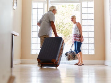 Personas mayores saliendo de viaje con maletas