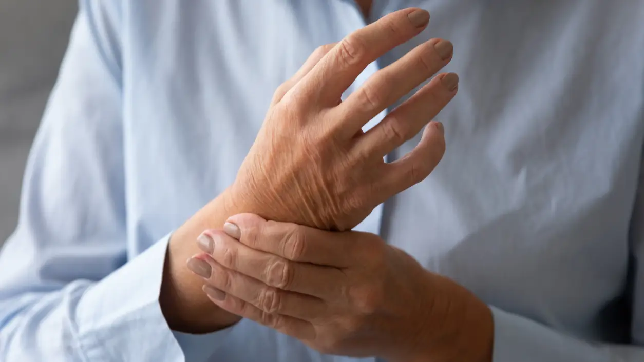 Señora mayor masajeando la mano que sufre de concepto de artritis reumatoide