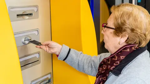 Señora mayor sacando dinero de un cajero Señora mayor sacando dinero de un cajero
