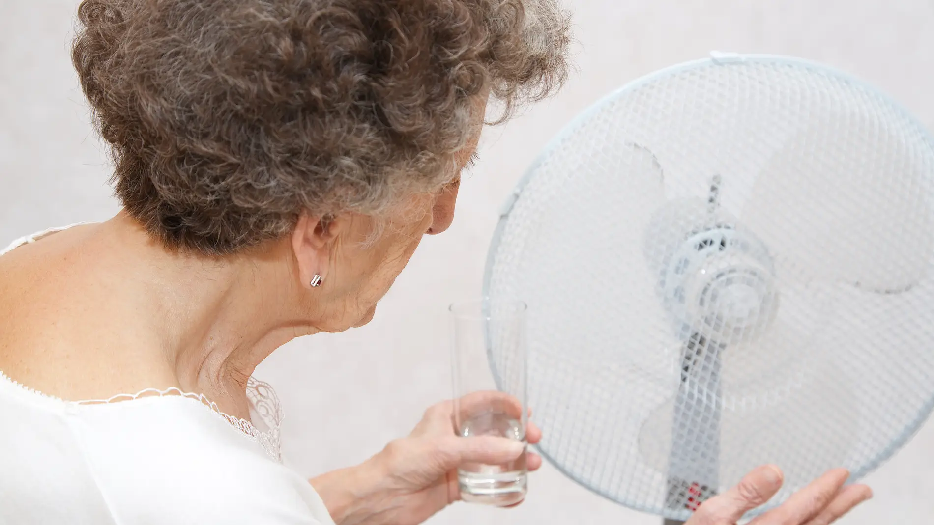 Mujer mayor con un ventilador