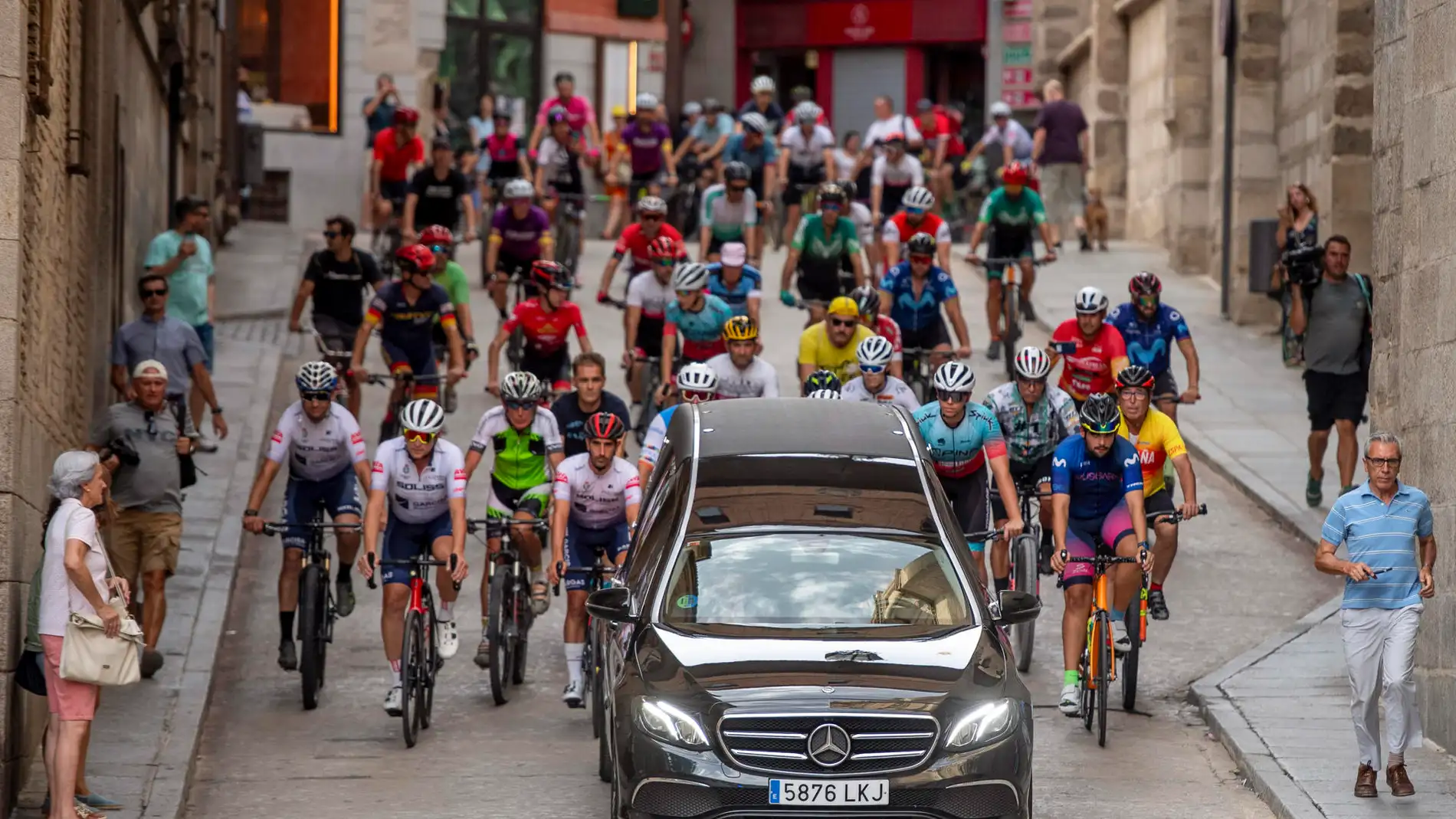 Un grupo de ciclistas sigue en caravana al coche donde se trasladan los restos de Federico Martín Bahamontes
