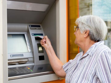Mujer mayor sacando dinero de un cajero