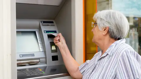 Mujer mayor sacando dinero de un cajero Mujer mayor sacando dinero de un cajero
