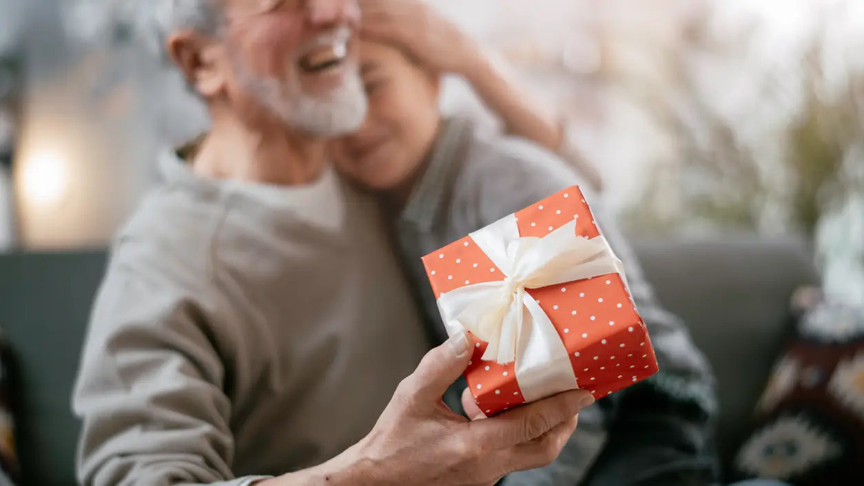 Un abuelo haciendo un regalo a su nieto