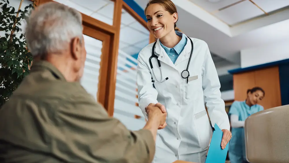 Un médico saluda a una persona mayor en la sala de espera