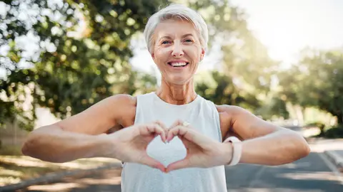 Mujer mayor haciendo un corazón con las manos Mujer mayor haciendo un corazón con las manos