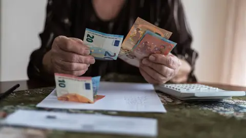 Mujer mayor calculando la pensión Mujer mayor calculando la pensión