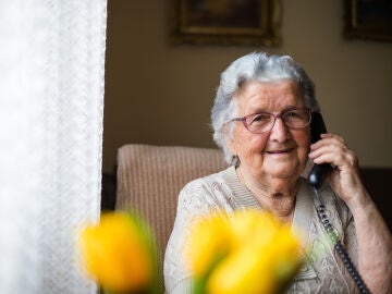 Persona mayor atendiendo al teléfono