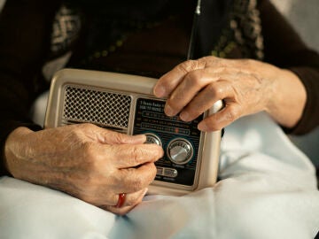 Persona mayor escuchando un transistor