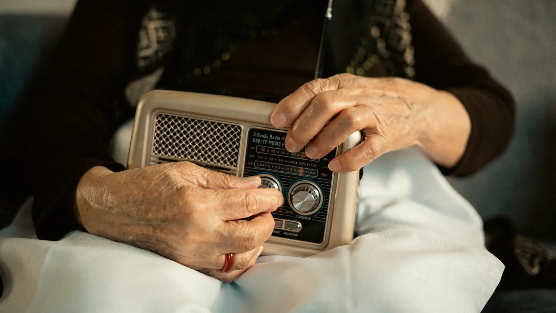 Persona mayor escuchando un transistor