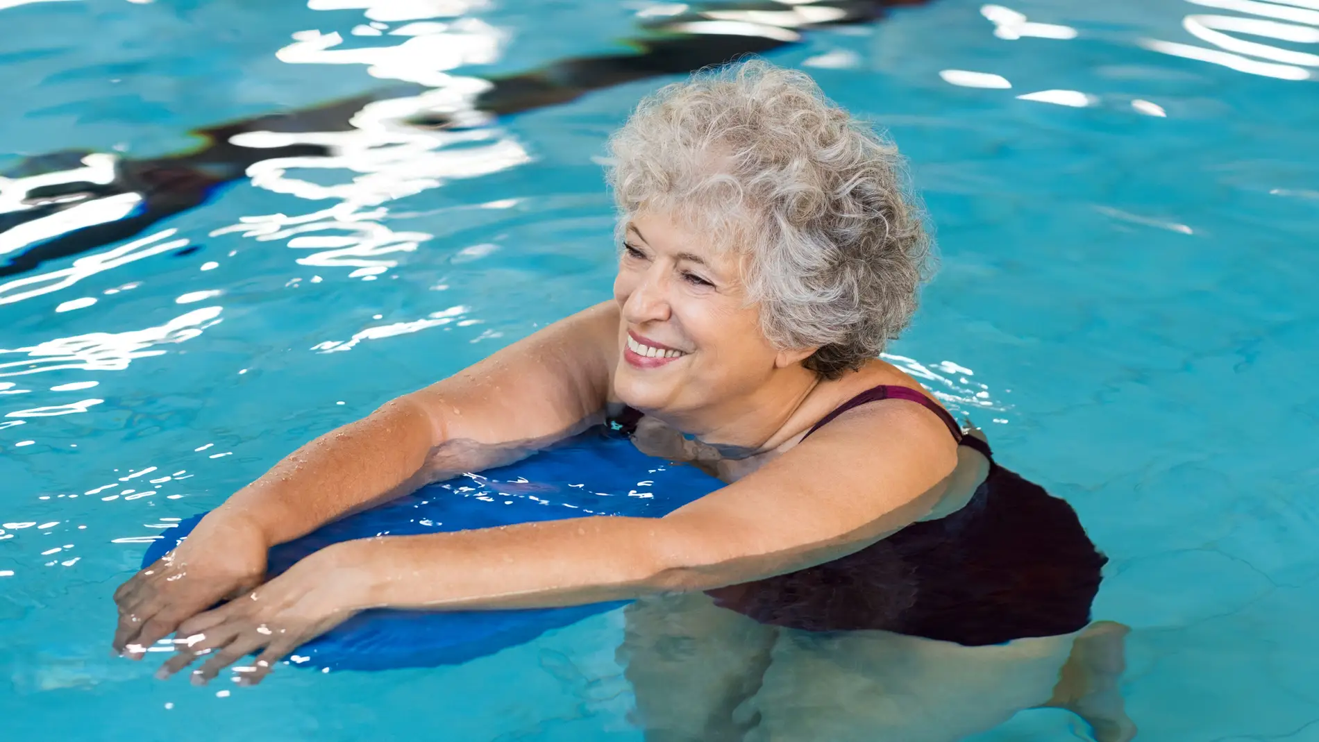 Mujer mayor nadando en una piscina