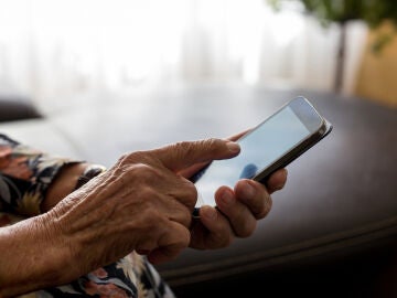 Una persona mayor usando el teléfono móvil