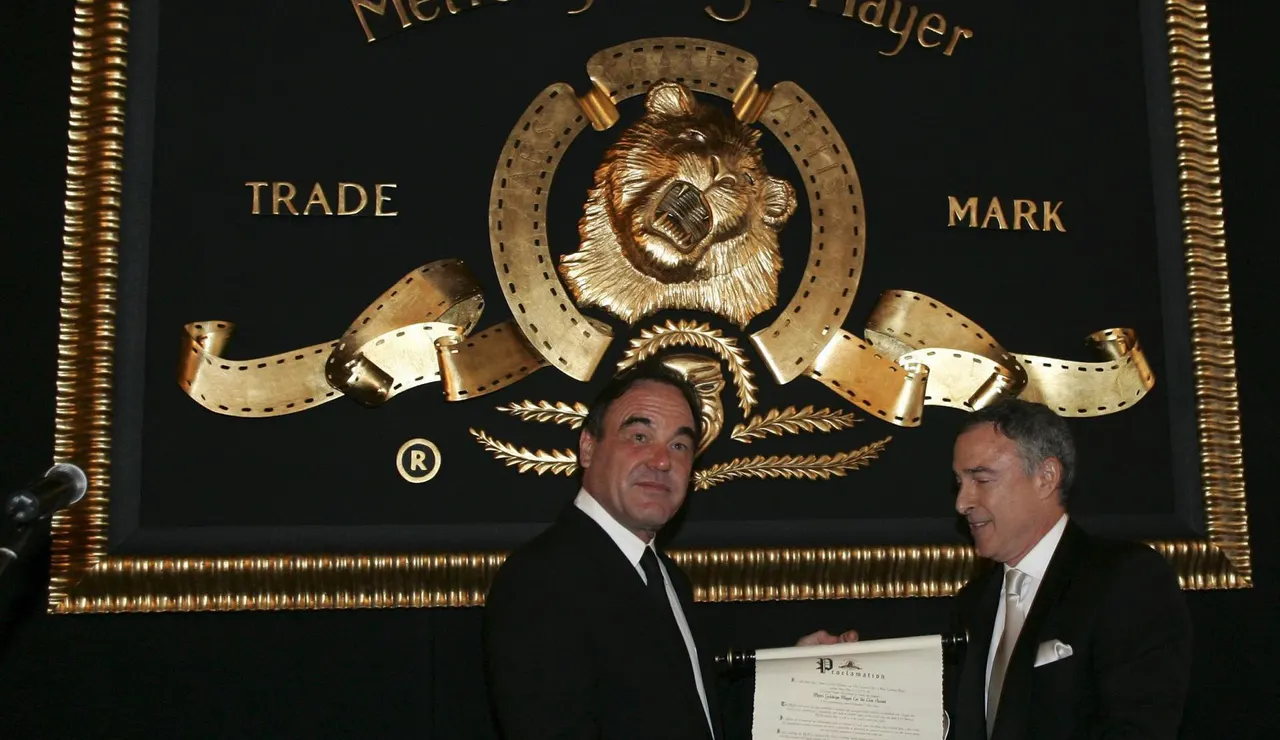 El director Oliver Stone, recibe el primer León anual de Metro-Goldwyn-Mayer (MGM) de las manos del presidente Harry Sloan 