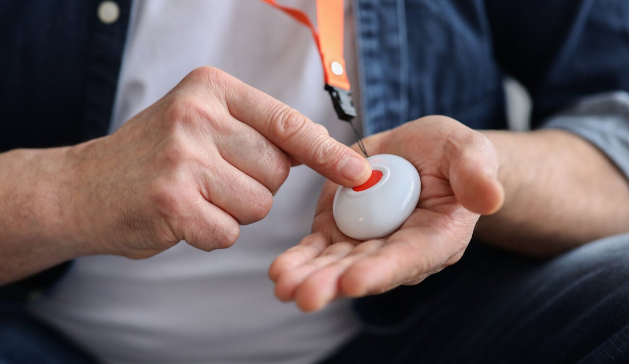 Persona pulsando el botón rojo de teleasistencia
