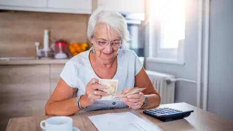 Mujer mayor contando su pensión Mujer mayor contando su pensión