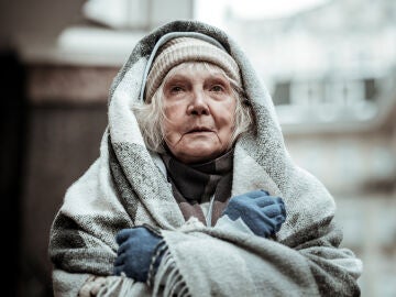 Mujer mayor arropada con una manta