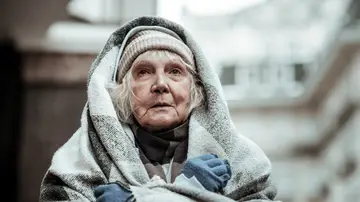 Mujer mayor arropada con una manta