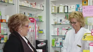 Una farmacéutica atendiendo a una señora mayor