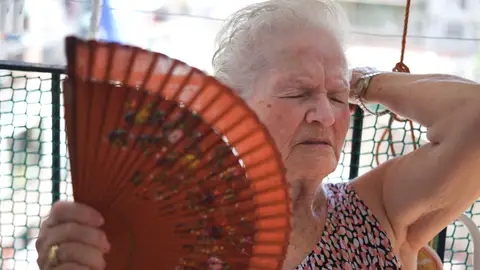 Mujer mayor con mucho calor abanicándose Mujer mayor con mucho calor abanicándose