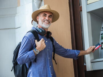 Hombre mayor feliz en un cajero