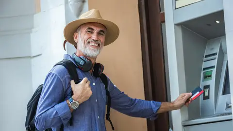 Hombre mayor feliz en un cajero Hombre mayor feliz en un cajero