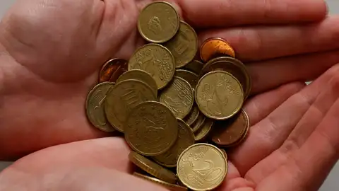 Mano con monedas en efectivo Mano con monedas en efectivo