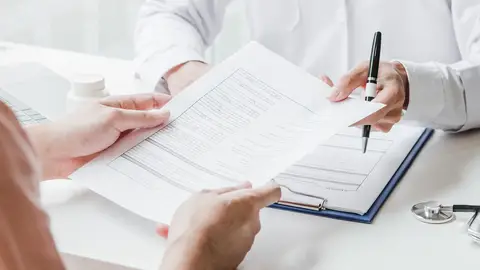 Médico entregando unos documentos Médico entregando unos documentos