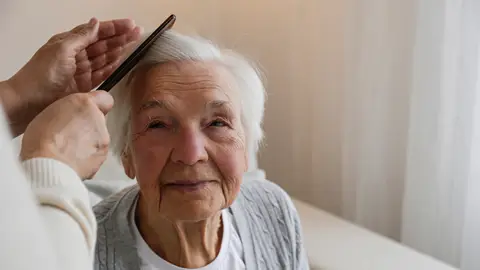 Mujer mayor mientras le peinan Mujer mayor mientras le peinan