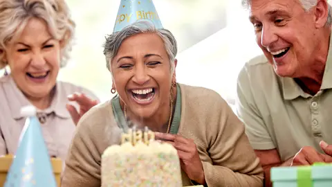 Una mujer mayor celebrando su cumpleaños Una mujer mayor celebrando su cumpleaños