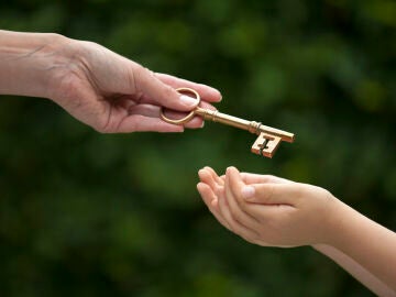 Mano mujer dando una llave a una mano joven