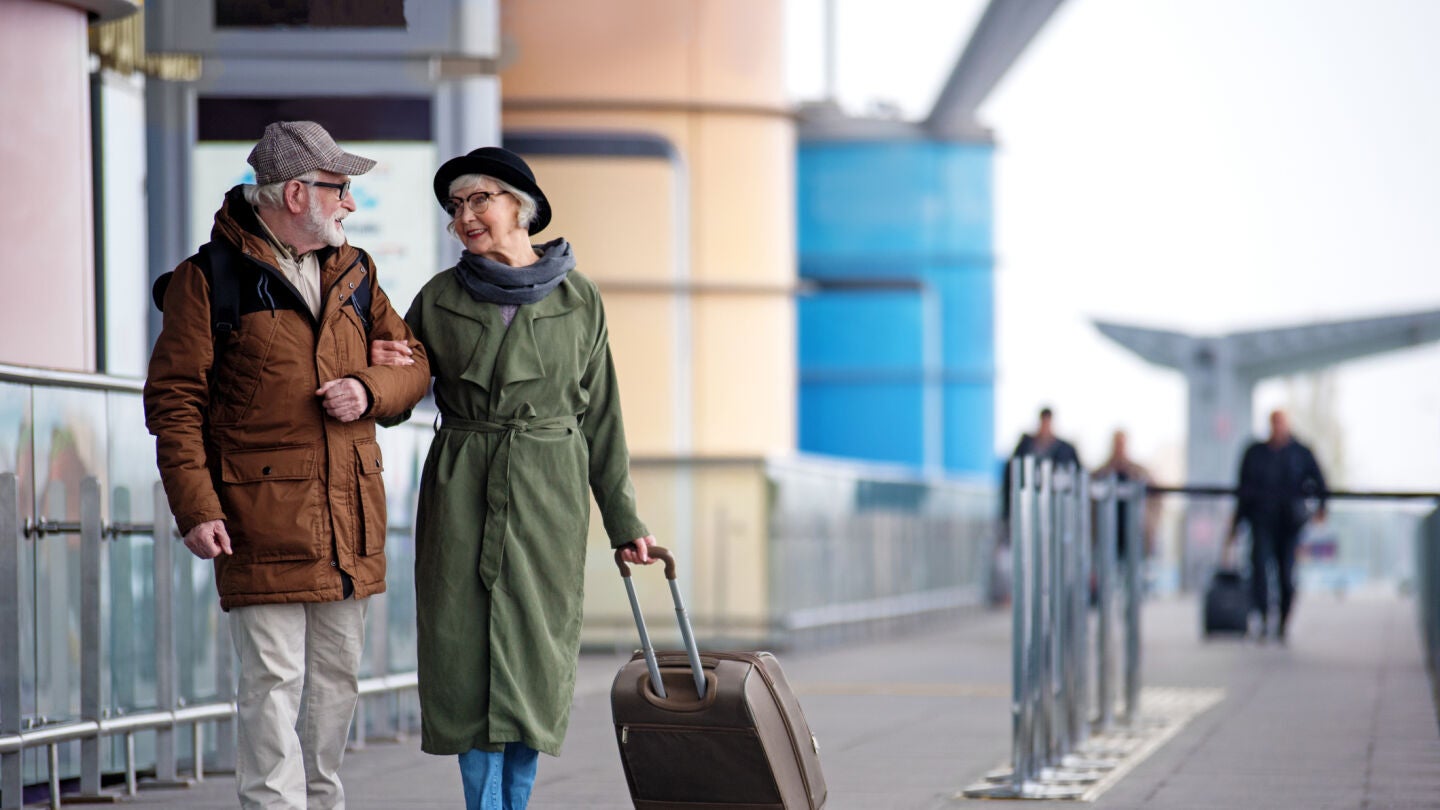 Pareja mayor de viaje con una maleta