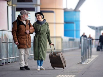 Pareja mayor de viaje con una maleta