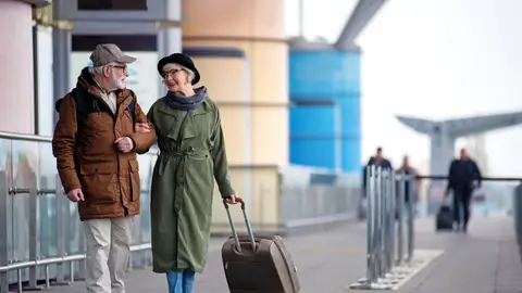 Pareja mayor de viaje con una maleta Pareja mayor de viaje con una maleta