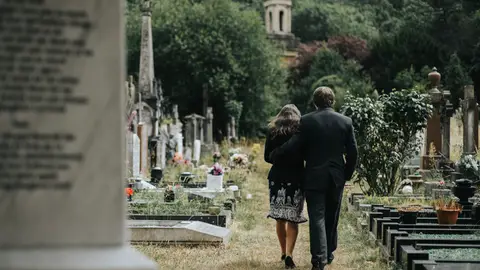 Una pareja visitando un cementerio Una pareja visitando un cementerio