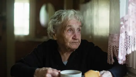 Mujer mayor desayunando sola Mujer mayor desayunando sola