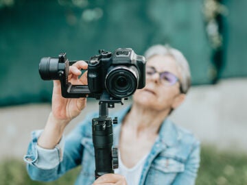 Mujer mayor usando una c&aacute;mara de fotos