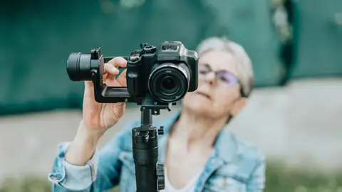 Mujer mayor usando una cámara de fotos Mujer mayor usando una cámara de fotos