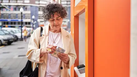 Mujer retirando dinero del cajero Mujer retirando dinero del cajero