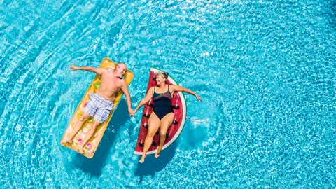 Pareja mayor disfrutando de la piscina Pareja mayor disfrutando de la piscina