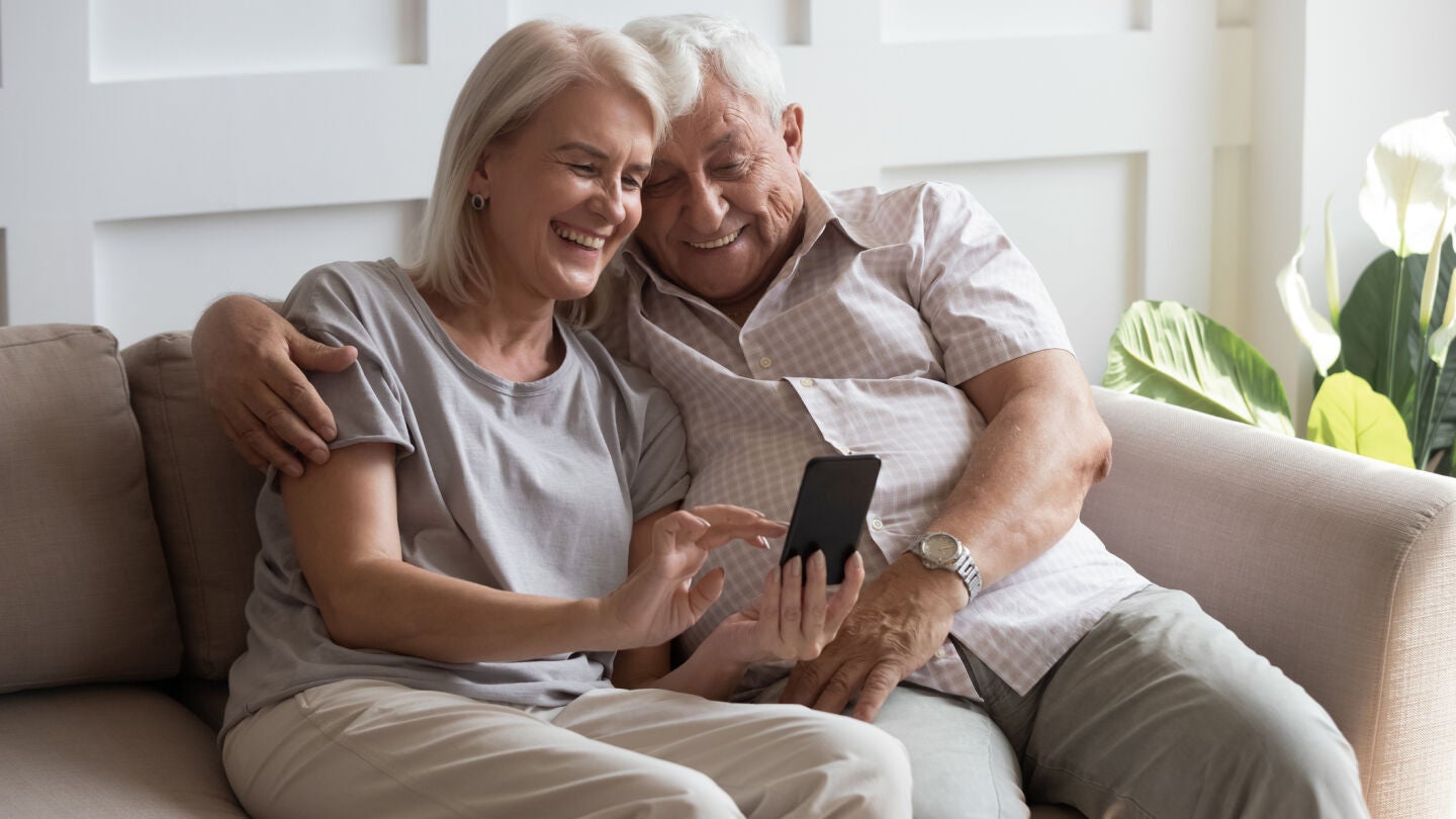 Pareja usando un tel&eacute;fono m&oacute;vil