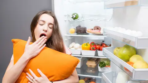 Mujer con sueño delante de la nevera Mujer con sueño delante de la nevera