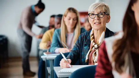 Mujer mayor atendiendo a una clase Mujer mayor atendiendo a una clase