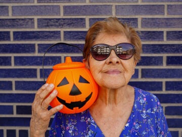 Mujer junto a una calabaza de Halloween de pl&aacute;stico