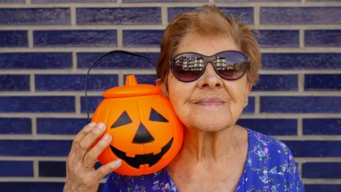 Mujer junto a una calabaza de Halloween de plástico Mujer junto a una calabaza de Halloween de plástico