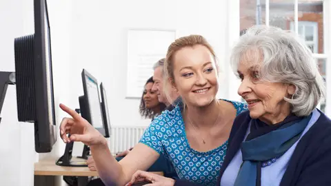 Mujer mayor aprendiendo a usar un ordenador Mujer mayor aprendiendo a usar un ordenador