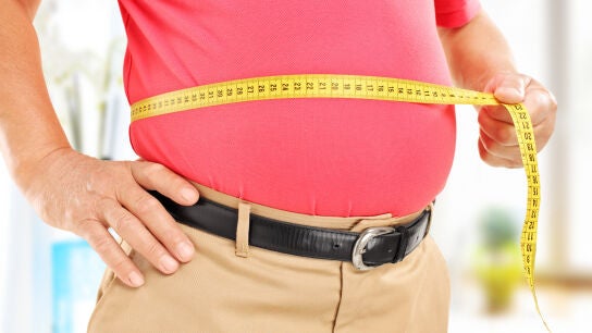 Hombre mayor midi&eacute;ndose la barriga